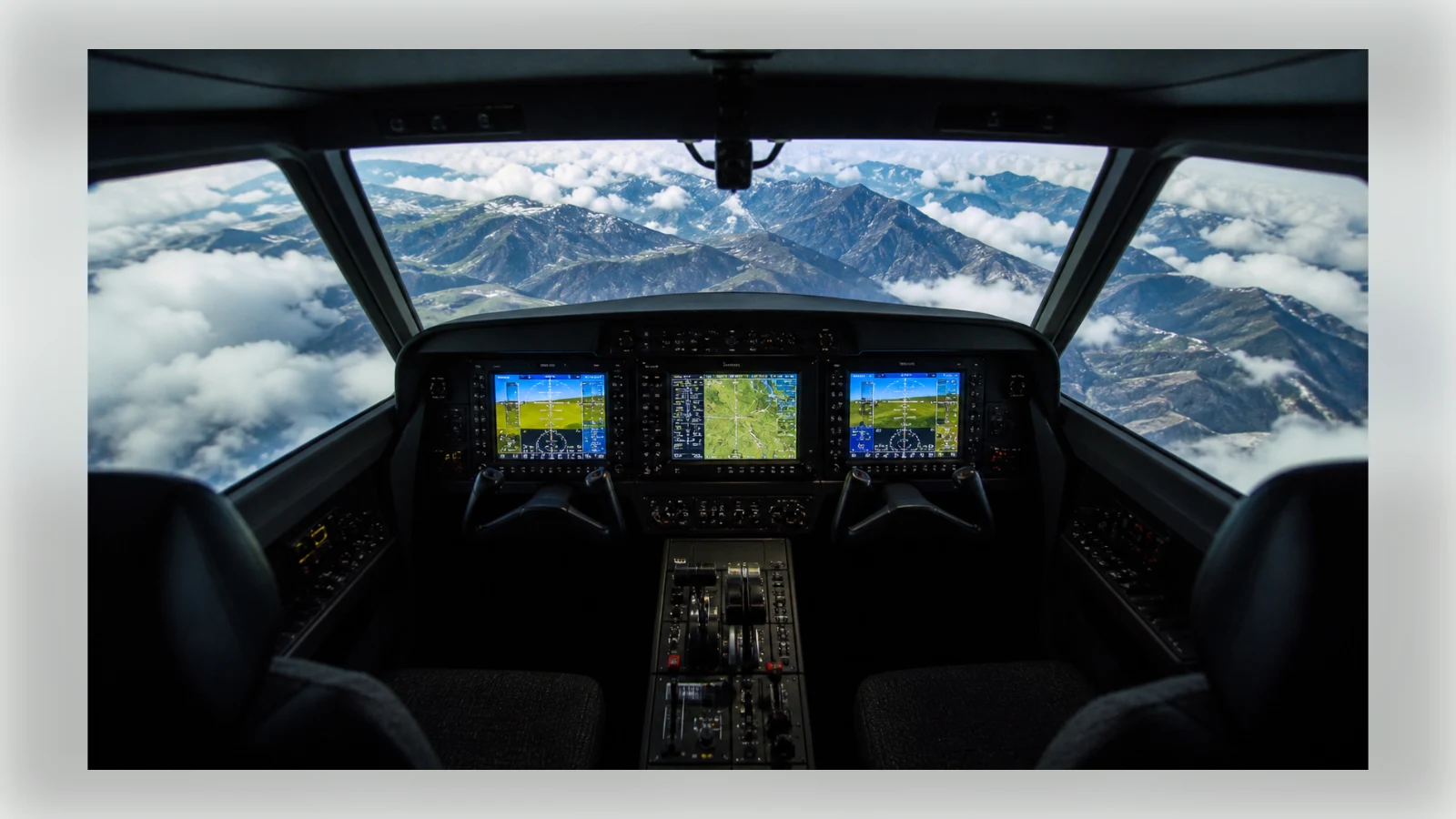 A realistic flight simulator cockpit overlooking a mountain landscape.